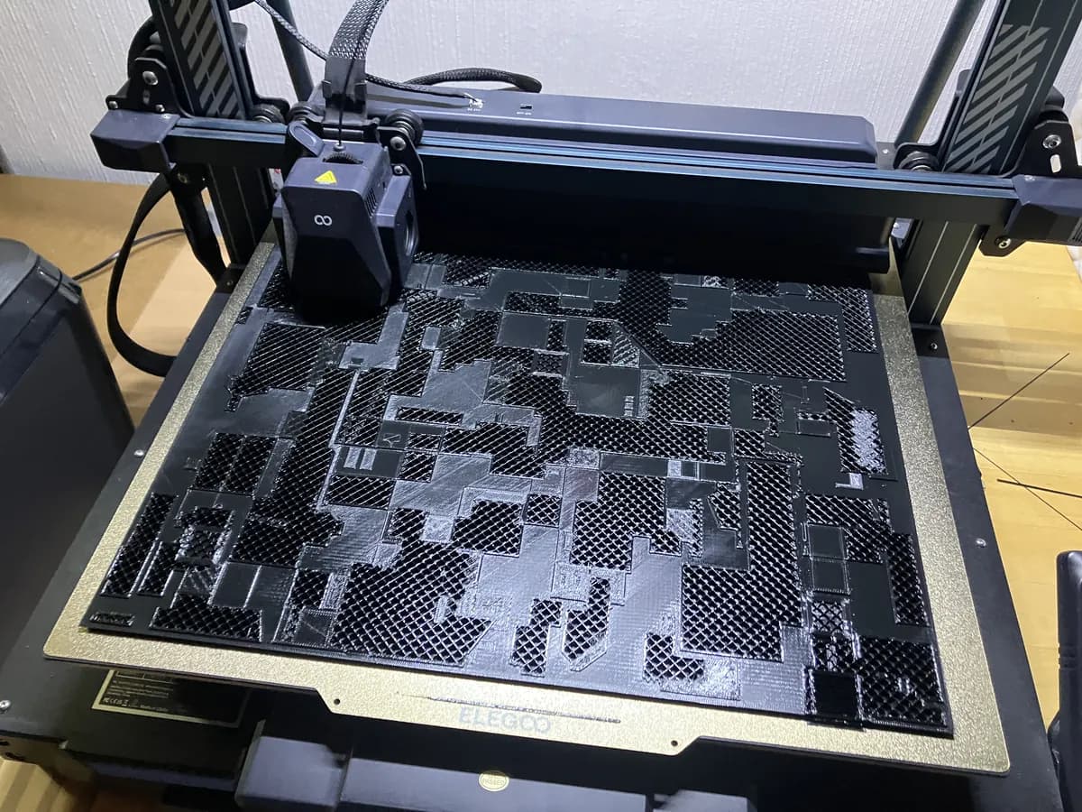 Ein 3D-Drucker druckt eine große, fein strukturierte Platte in Schwarz.